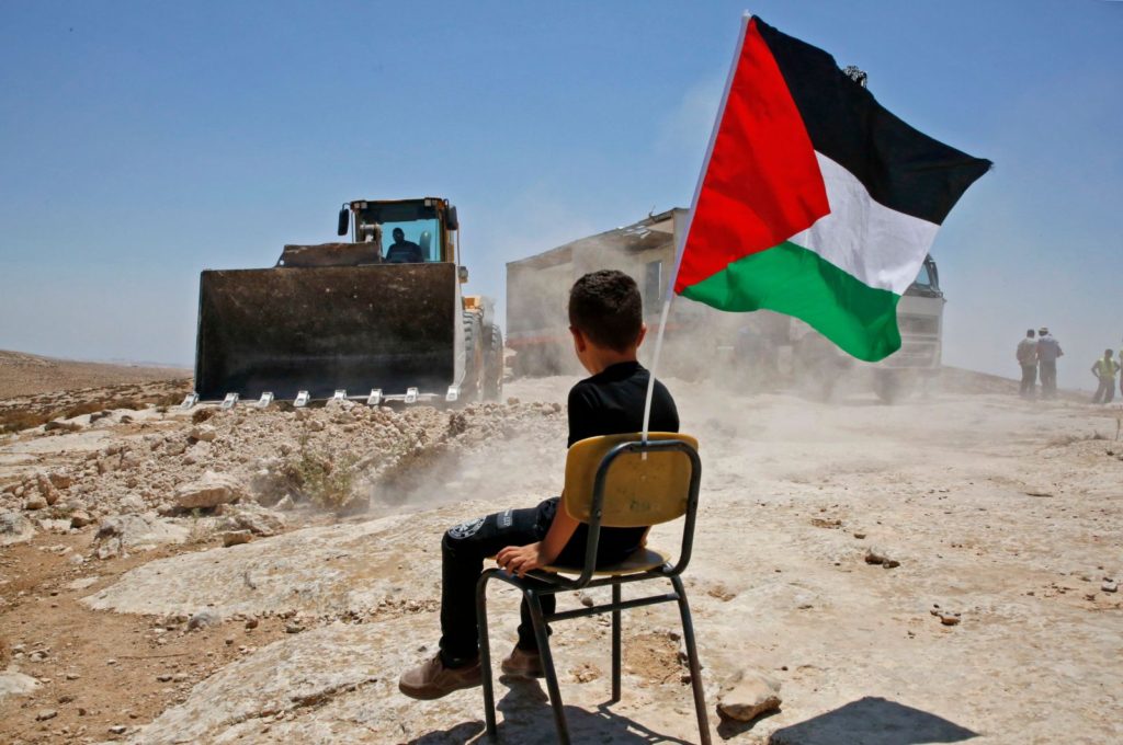 Palestinski deček opazuje rušenje šole v vasi Yatta, 11. julij, 2018.