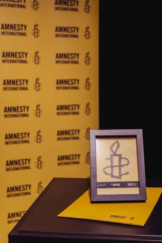 Zaključna prireditev Festivala dokumentarnega filma 2025. Na fotografiji nagrada Amnesty International.