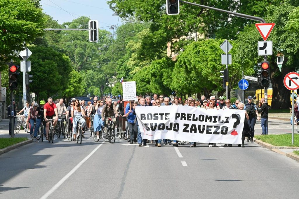 Protest, osebe s transparentom z napisom Ali boste prelomili svojo zavezo?
